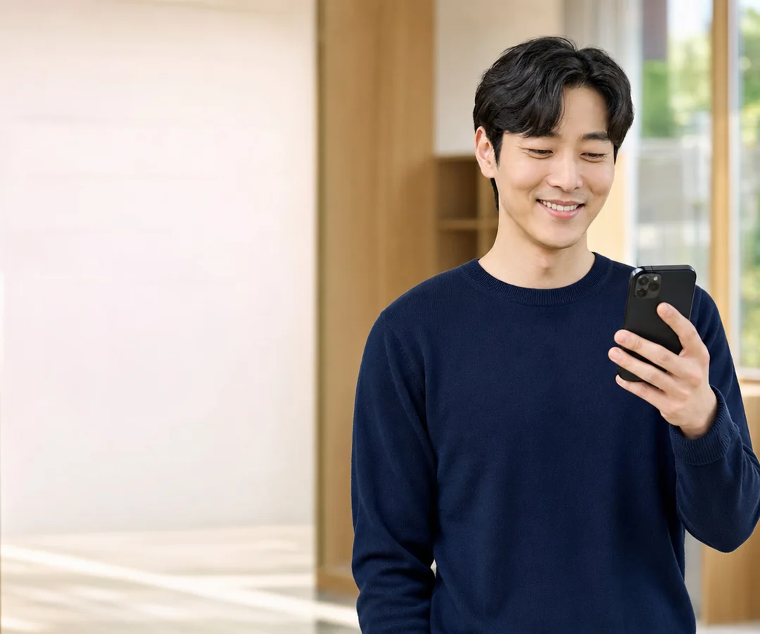 밝은 상담 공간에서 휴대전화로 문의하며 웃고 있는 이십 대 여성의 모습
